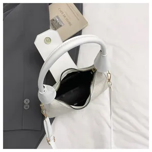 Top view of a white stone-textured handbag featuring a magnetic flap and a black lining