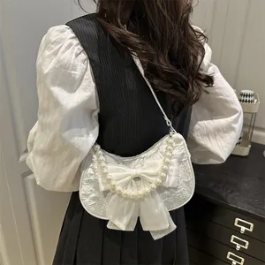 Elegante borsa bianca con manico di perle, grande fiocco di seta e trama jacquard