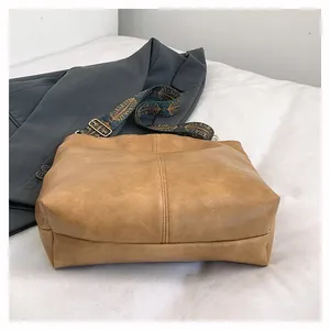 Brown vintage faux leather tote bag with a bohemian patterned wide shoulder strap
