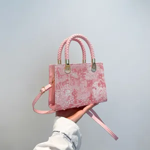 Pink floral French style crossbody bag with woven handle and gold hardware