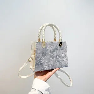 French style crossbody bag with jacquard texture and white woven handle in front view