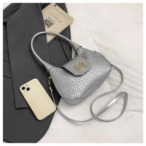 Macro detail of silver woven textured crossbody bag with golden M logo and metallic finish