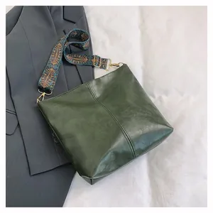 Close-up of vintage green tote bag featuring high-quality leather texture and jacquard strap