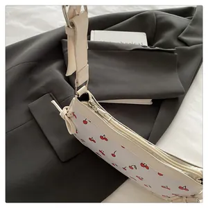 Dettaglio della borsa con stampa a ciliegie, zip argentata e fiocco decorativo