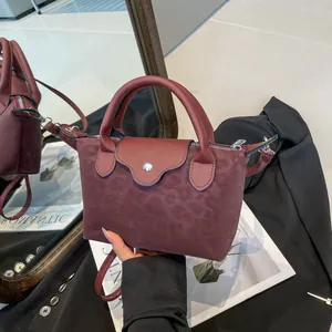Chic burgundy leopard print suede handbag with top handles and crossbody strap