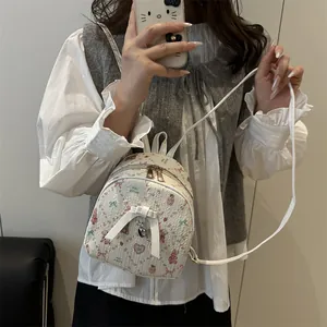 Mini white floral backpack with pink bow pattern and metallic heart pendant for women