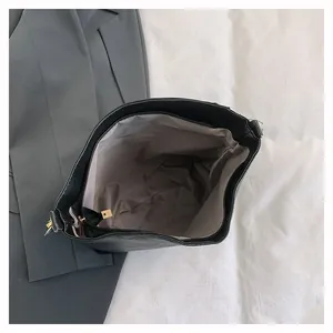 Top view of the black leather tote bag interior with gray lining and gold metal zipper
