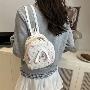 Chic cream mini backpack with pink bear and bow patterns shown on a model's back