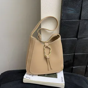 Bolso tipo cubo retro caqui claro con anillo de metal y costuras blancas grandes