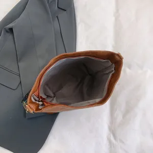Top view of brown PU leather tote bag with gray fabric lining and zipper closure