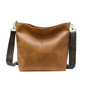 Brown tote bag with natural leather texture and colorful ethnic style wide shoulder strap