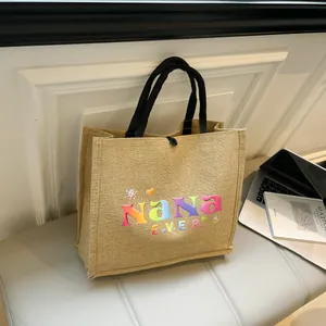 Detailansicht der Jute-Einkaufstasche mit buntem Nana EVER Logo und schwarzen Tragegriffen