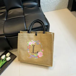 Detail der Jute-Einkaufstasche mit floralem L-Monogramm und schwarzen Seilgriffen