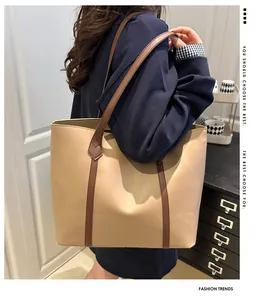 Detail of contrast stitch tote bag with brown straps worn on shoulder by model