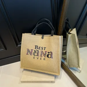 Detailansicht der Leinentasche mit buntem Best Nana Ever Aufdruck und schwarzen Henkeln