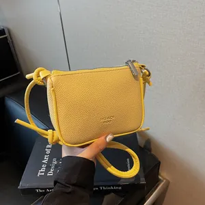 Minimalist bright yellow small crossbody bag with premium lychee grain texture and zipper