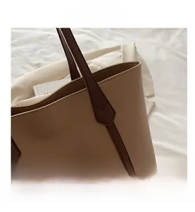 Detail shot of the stitching on a color-block tote bag with a minimalist lifestyle background