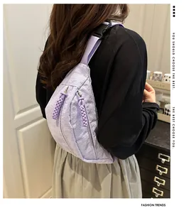 Detail of light purple corduroy crossbody bag showing texture and adjustable strap on back