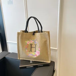 Detailaufnahme der Jute-Einkaufstasche mit floralem H-Druck und schwarzen Seilgriffen