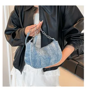 Close-up of light blue denim hobo bag with silver chain strap and washed texture
