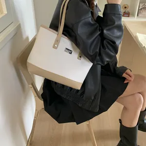 Chic canvas and leather tote bag shown on model, minimalist shoulder bag for daily commuting