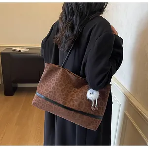 Dettaglio della borsa tote leopardata retrò con manici neri e ciondolo in peluche