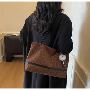 Dettaglio della borsa tote leopardata con ciondolo a mostro di peluche e tracolla in pelle