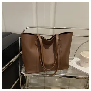 Detail showing high-quality dark brown leather texture and stitching on large tote bag