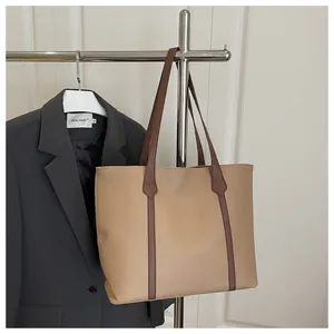 Close-up of contrast stitching and two-tone brown PU leather detail on tote bag