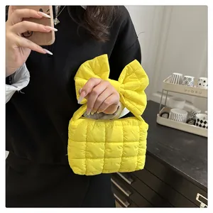 Borsa a mano trapuntata giallo brillante con grande manico a fiocco in ambiente casa