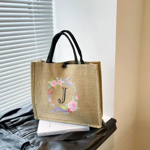 Detail der Jute-Einkaufstasche mit floralem J-Druck und rundem Handgriff