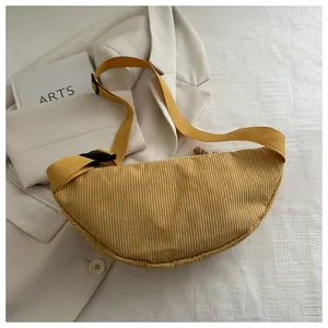 Detail of yellow corduroy crescent bag with textured stripes and adjustable black buckle