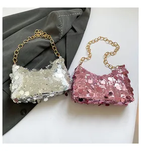 Detail of sequined dumpling bags in silver and lilac with thick gold chain handles