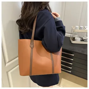 Brown leather tote bag showing large capacity and stylish shoulder fit on a model