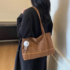 Borsa tote marrone maculata con ciondolo a mostro in peluche e cappotto nero lungo