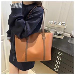 Detailed side view of brown leather tote bag showing large capacity and handle structure