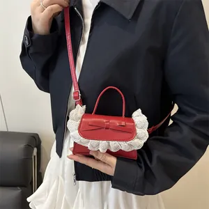 Rote Mini-Handtasche mit Schleife und weißem Spitzenbesatz am Modell für den Sommer