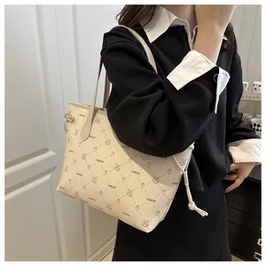 Vue latérale du sac cabas en cuir crème avec imprimé lapin, lettres et détails coulissants