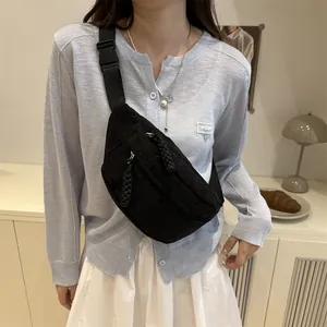 Minimalist black corduroy chest bag with adjustable strap worn by a female model