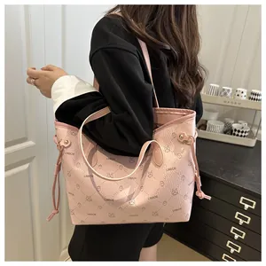 Détail du cabas rose avec imprimé lapin, texture litchi et cordons latéraux