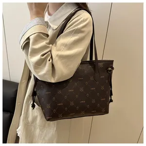 Sac cabas marron avec monogramme LNBOE et motifs cartoons porté avec un trench beige