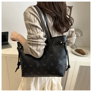 Vue lifestyle d'un grand sac cabas noir à motifs de dessins animés et détails dorés