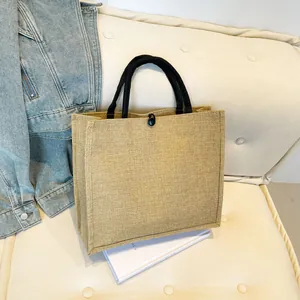 Strapazierfähige beige Leinentasche mit schwarzen Henkeln auf weißem Cordstoff