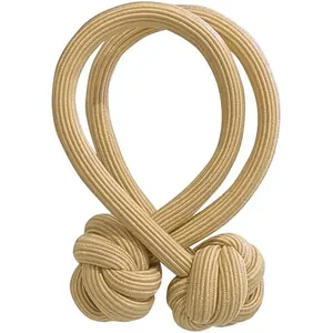Paar beige gevlochten gordijnophouders met decoratieve aapvuistknopen in Scandinavische stijl