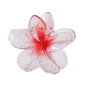 Detail von Haarklammer mit rosa Farbverlauf, Glitzer und Metallfeder in Blumenform