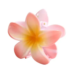 Makroaufnahme der 8cm Farbverlauf-Haarklammer mit Plumeria-Blüte und goldener Feder