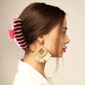 Grande molletta per capelli in acrilico marmorizzato rosa e bianco su una modella