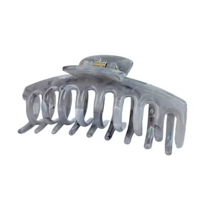 Dettaglio della pinza per capelli in acetato blu marmorizzato con molla in metallo dorato