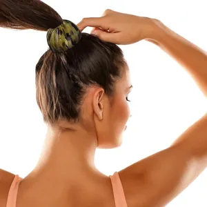 Green and black leopard print bird nest hair clip securing a ponytail on a female model