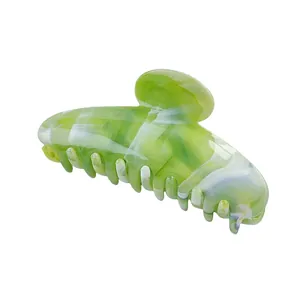 Macro detail of marble green and white acetate claw clip showing smooth teeth and texture